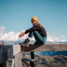 Alpin Loacker Merino pitkähihainen paita naisille mustassa, tyttö istuu vuorien edessä
